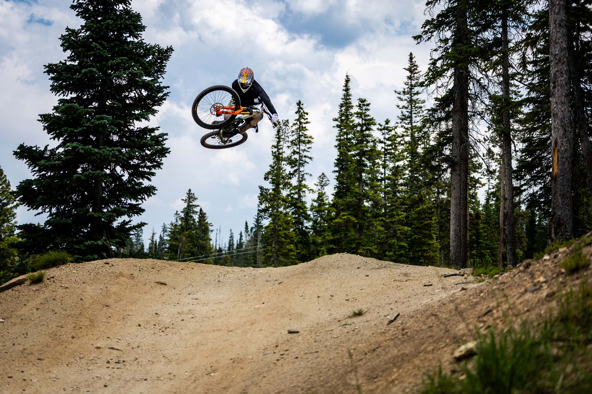 Mountain biker performing a jump on a dirt track, showcasing the thrill of RKT Optics.