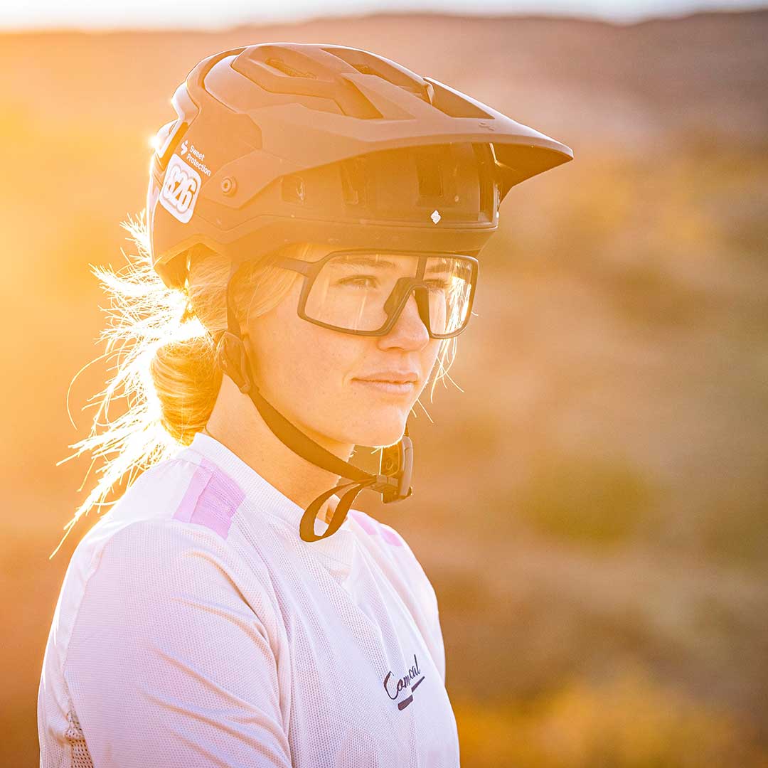 Woman in mountain biking helmet and goggles, ready for a ride.
